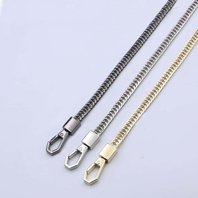 3 chaines de sacs en métal argent, Stål et doré avec mousquetons sur fond gris