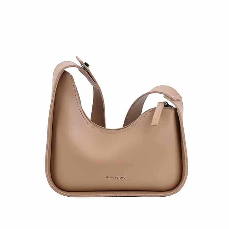 Photo d'un petit sac à bandoulière asymétrique en cuir synthétique beige