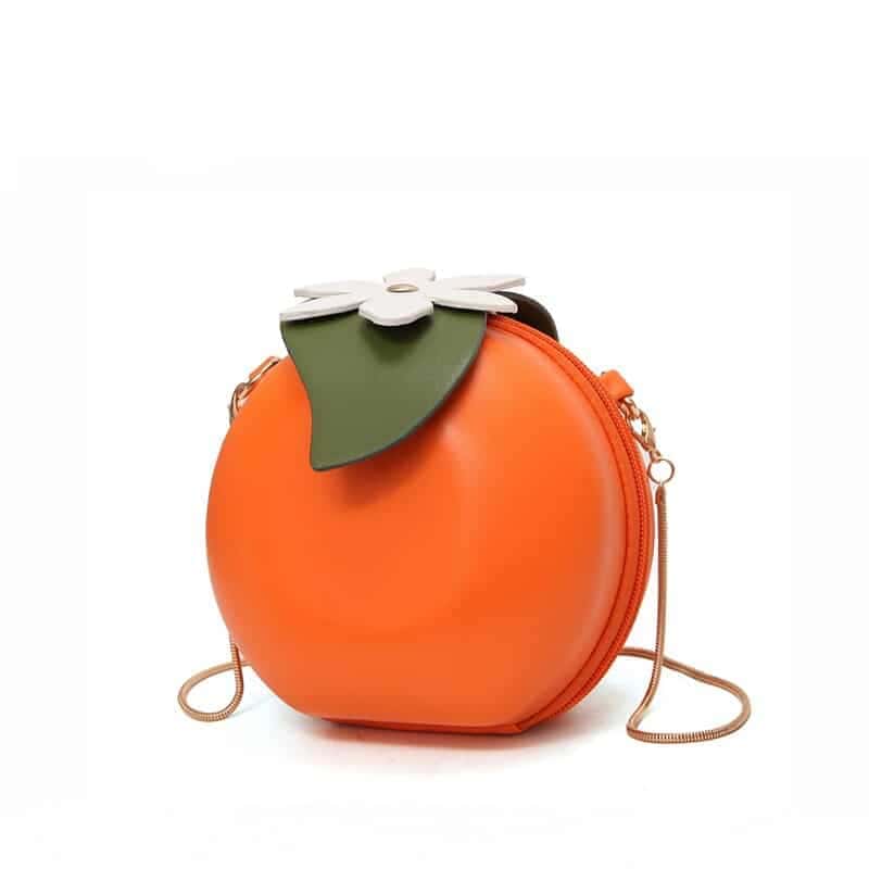 Petit sac à bandoulière en forme de fruit orange sur un fond Vit