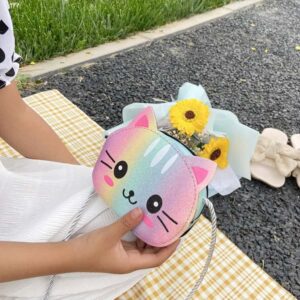 On voit une main d'enfant qui tient un sac à bandoulière motif tête de chat multicolore