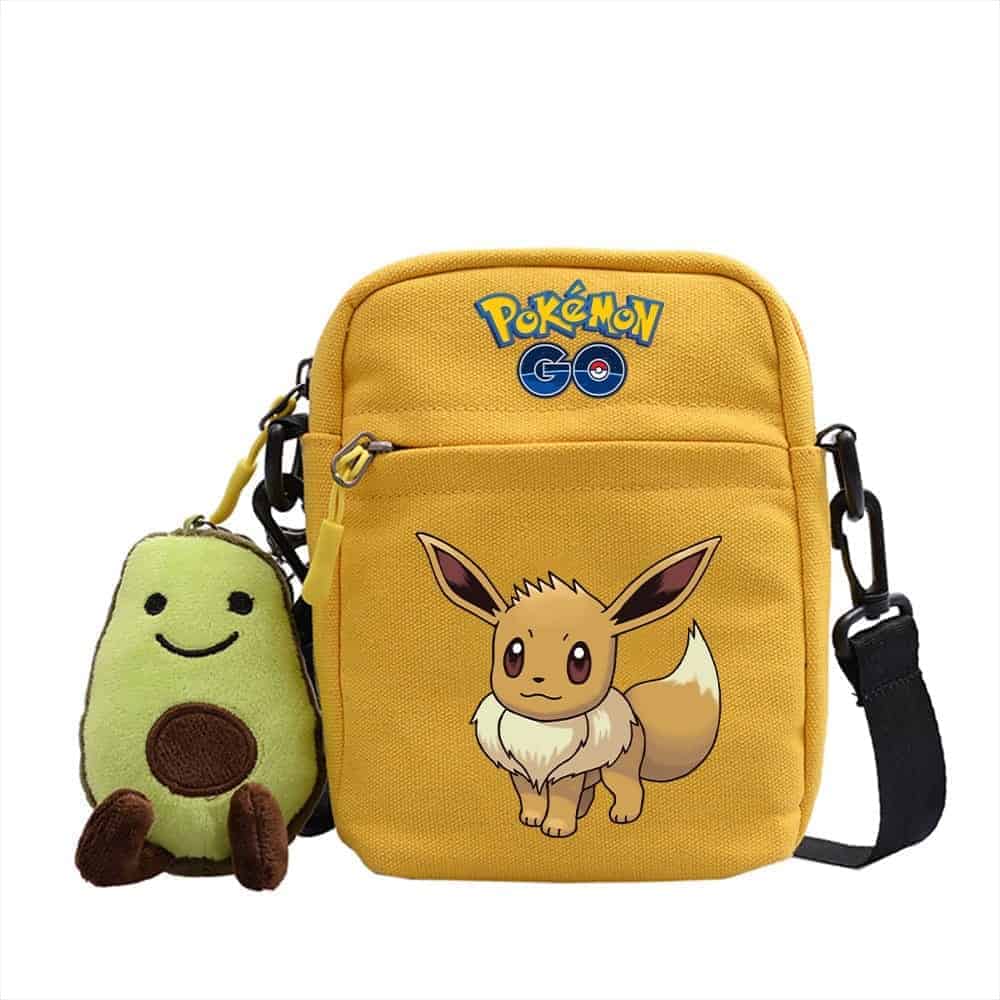 Photo d'une sacoche bandoulière Gul pokémon go avec evoli dessus et une peluche Gröne à coté de la sacoche.