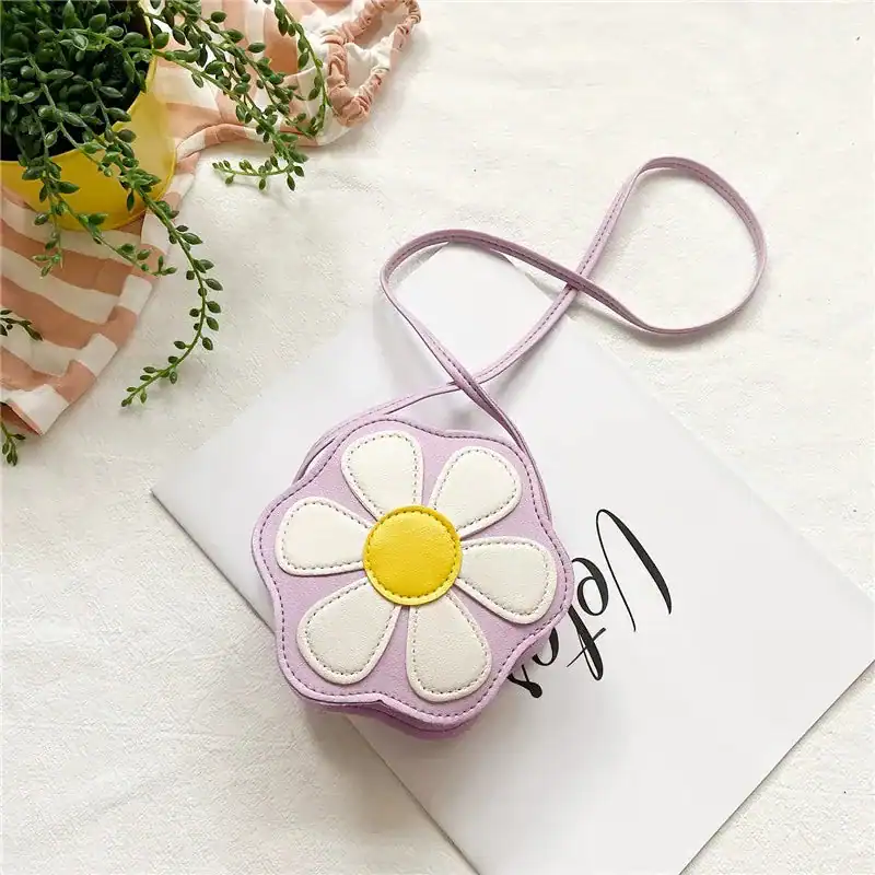Lila barnväska i blommaform med vit och gul detalj.