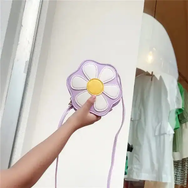 Lila barnväska i blommaform med vit och gul detalj.
