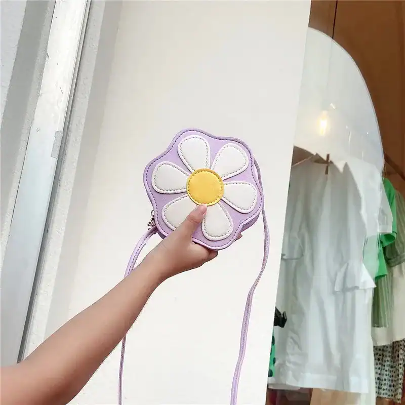 Lila barnväska i blommaform med vit och gul detalj.