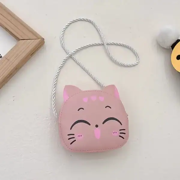 Liten rosa barnväska i kattform med vit axelrem.