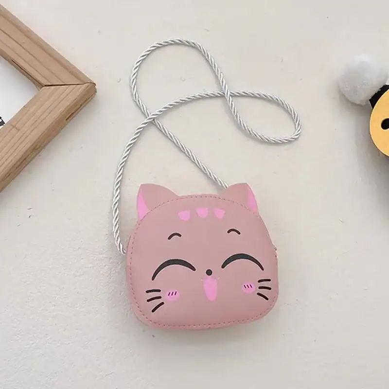 Liten rosa barnväska i kattform med vit axelrem.