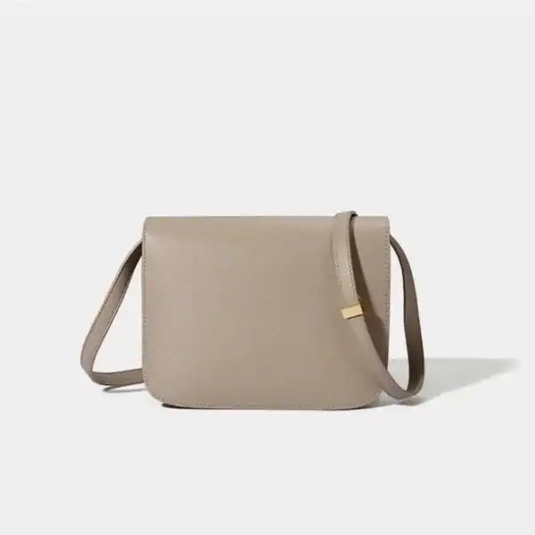 Beige axelremsväska med guld detalj och minimalistisk design.