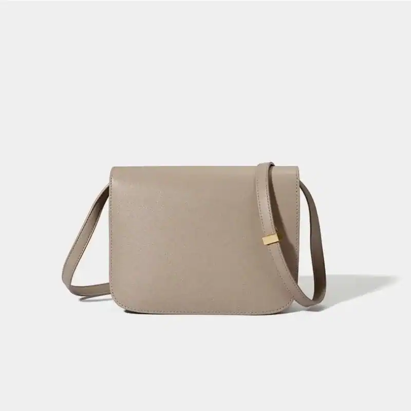 Beige axelremsväska med guld detalj och minimalistisk design.