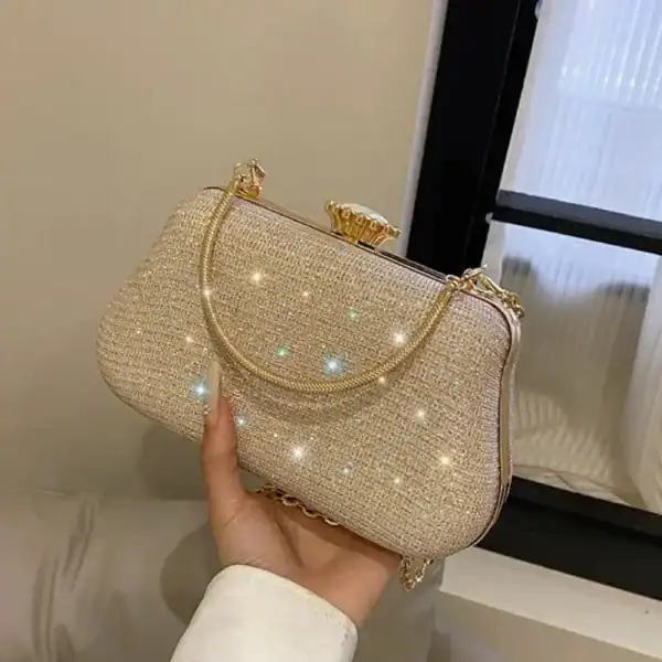 Beige clutch med glittrande pärlor och guldhandtag.