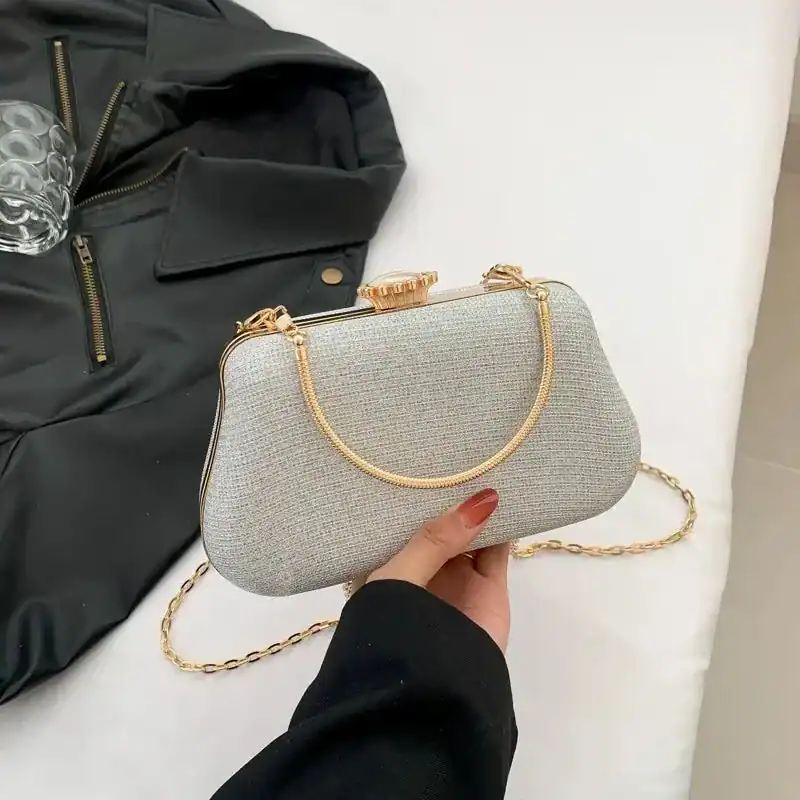 Beige clutch med gyllene kedjehandtag och elegant design.