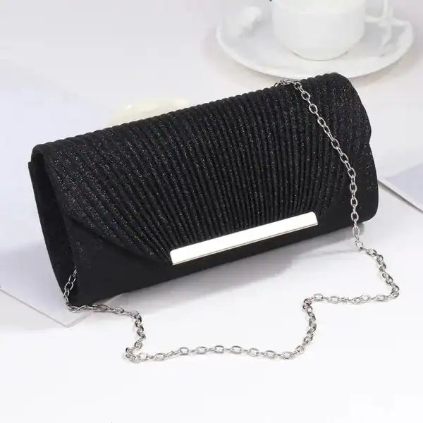 Svart glittrig clutch med kedjehandtag och plisserad yta.