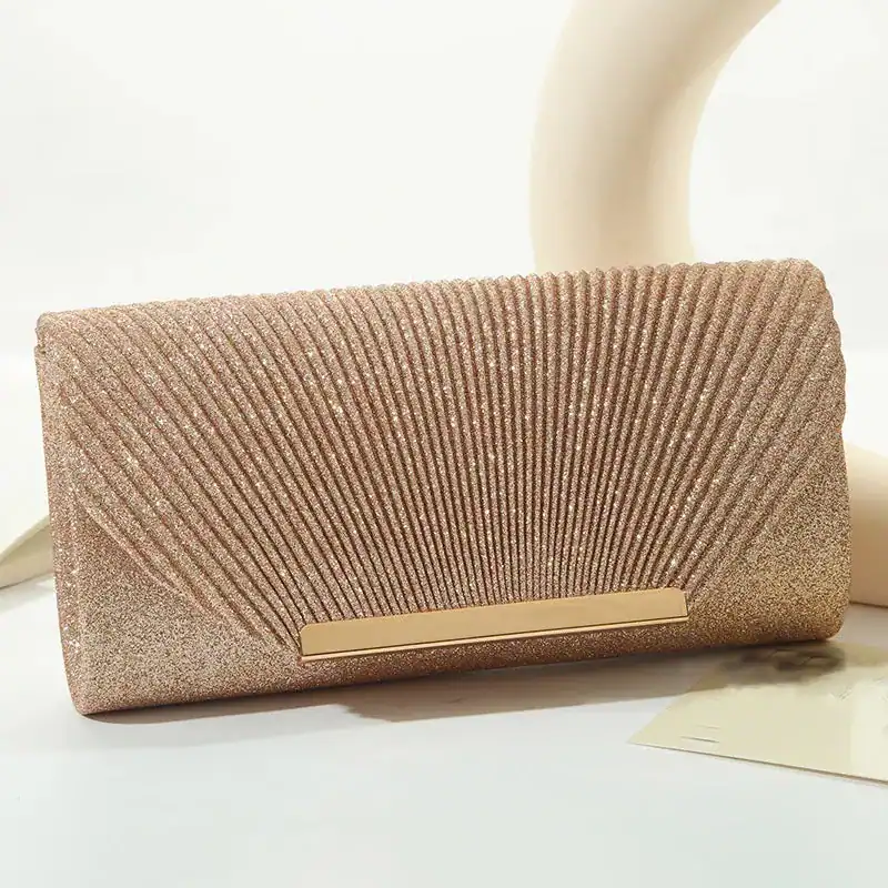 Beige glittrig clutch med gyllene snäppa och strukturerad yta.