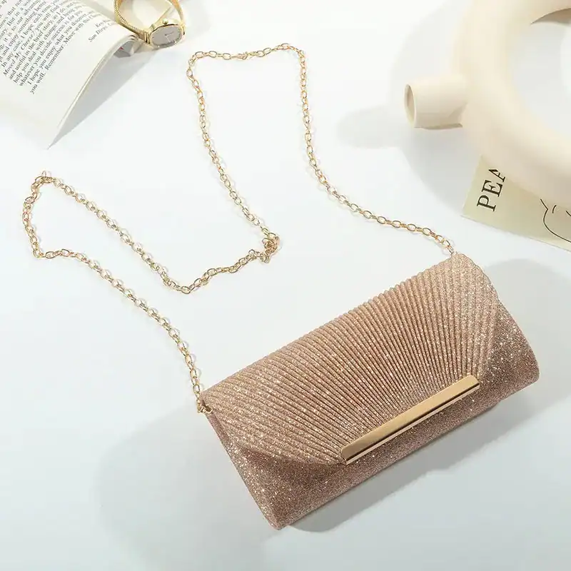 Beige glittrig clutch med gyllene kedjehandtag och eleganta design.