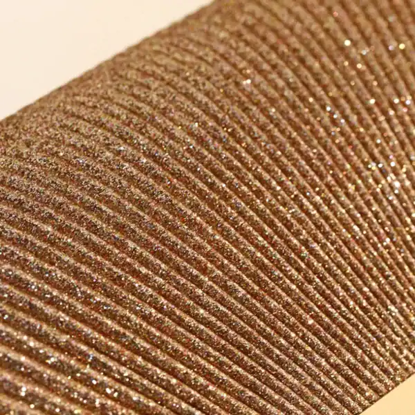 Beige glittrig clutch närbild, textil med glittriga detaljer och strukturerad yta.