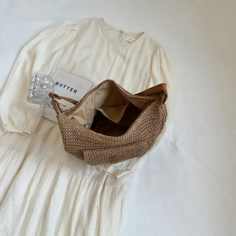 Beige halvmånsväska i rödstrå, ideal för sommar och dagliga utgångar.