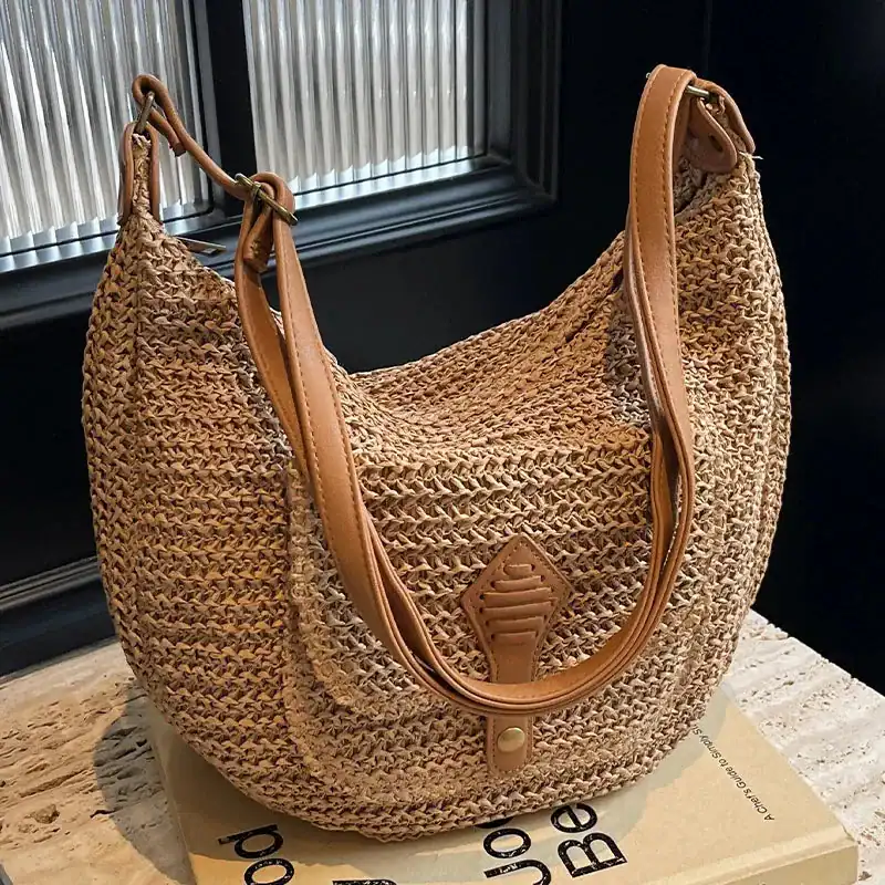 Beige halvmånsväska i rörsnitt, lämplig för sommar och strand.