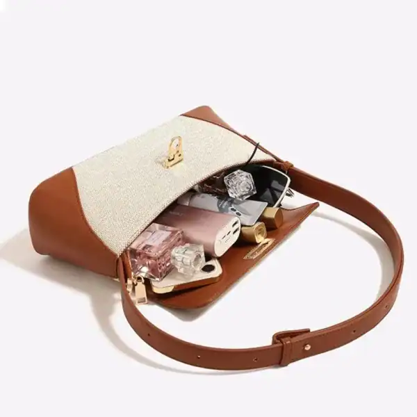 Beige handväska med brunt läder, öppen för att visa innehåll och praktiskt design.