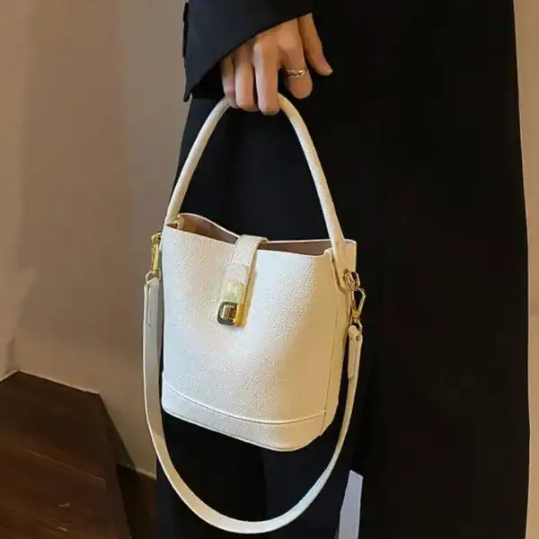 Beige hinkväska med lås, elegant handväskor för dam, läderliknande textur.