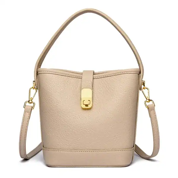 Beige hinkväska med lås, elegant handväska med axelrem och guldaktig snäppa.