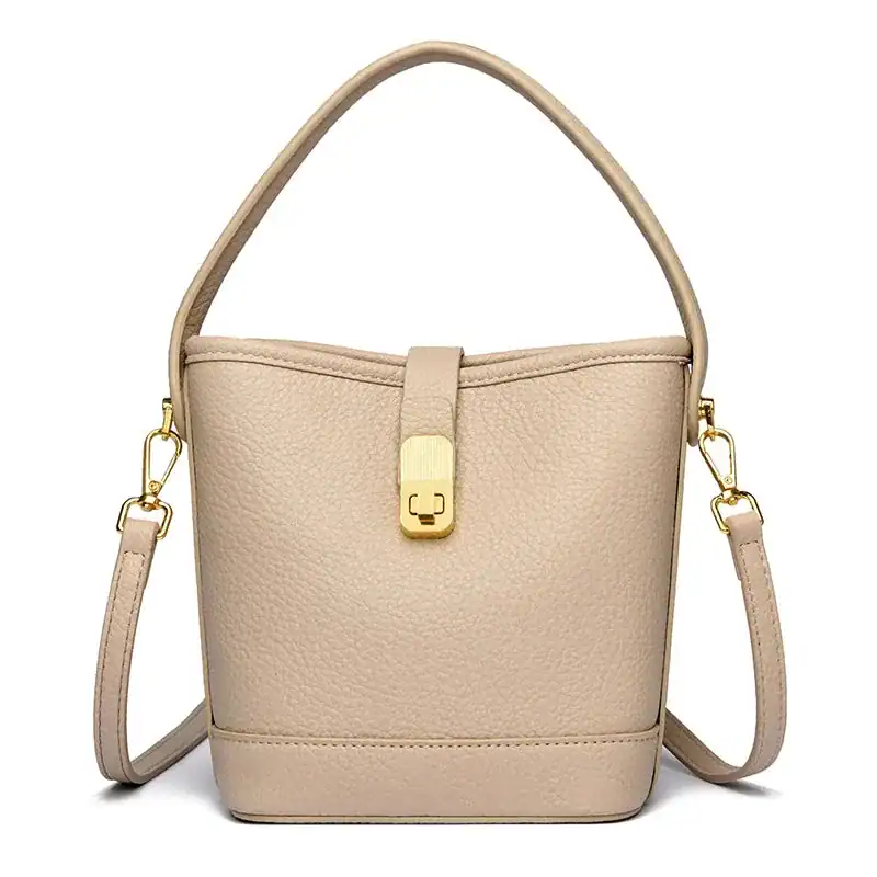 Beige hinkväska med lås, elegant handväska med axelrem och guldaktig snäppa.