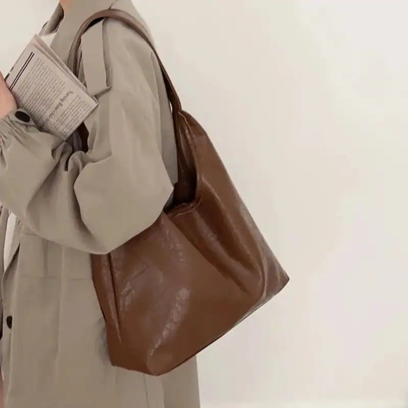 Beige hoboväska i läder, modeväska med stor kapacitet och elegant design.