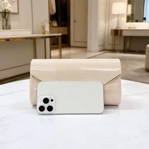 Beige kuvertclutch med kedja och telefon för storleksjämförelse.
