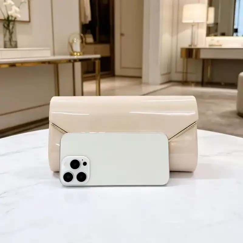 Beige kuvertclutch med kedja och telefon för storleksjämförelse.