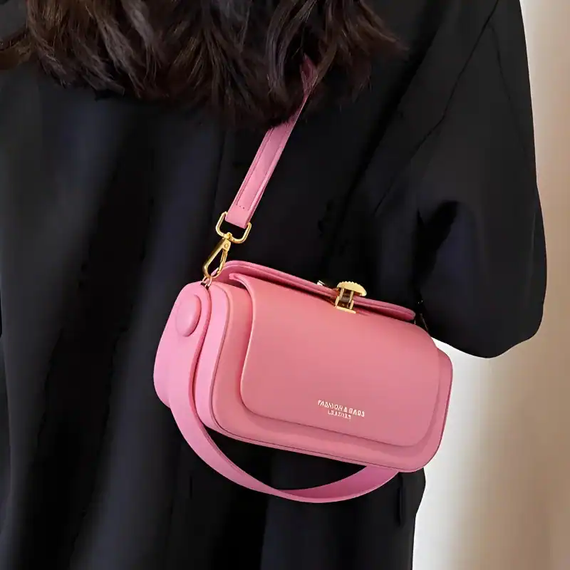 Beige liten crossbody axelväska i rosa, modeväska med guld detaljer och axelrem.