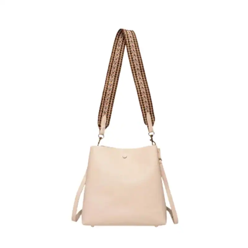 Beige liten hinkväska med mönstrad axelrem.