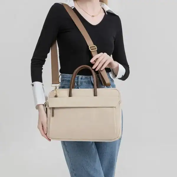Beige nylon datorväska med axelrem och handtag för kvinnor.