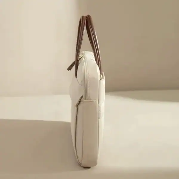 Beige nylon datorväska med bruna handtag och zippad framsida.