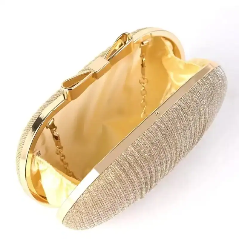 Beige oval clutch med gyllene detaljer och satänginre.