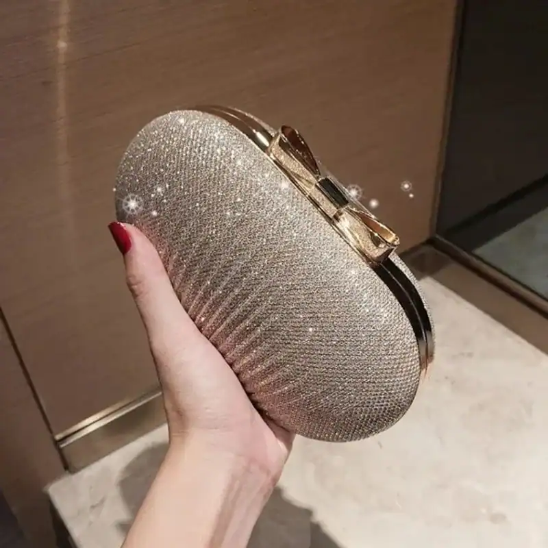 Beige oval clutch med glittrande pärlor och guldaktig snäcka.