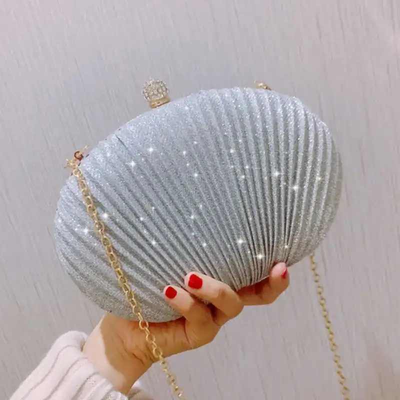 Beige oval festclutch med glittrande yta och gyllene kedja.
