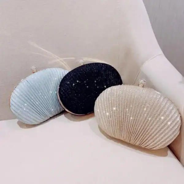 Ovala festclutch i beige, svart och ljusblå med glittrande detaljer.