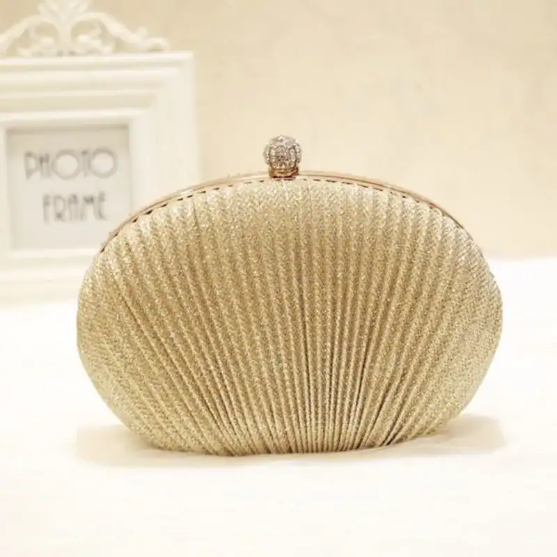 Beige oval festclutch med strukturerad textur och kristallbesatt snäcka.