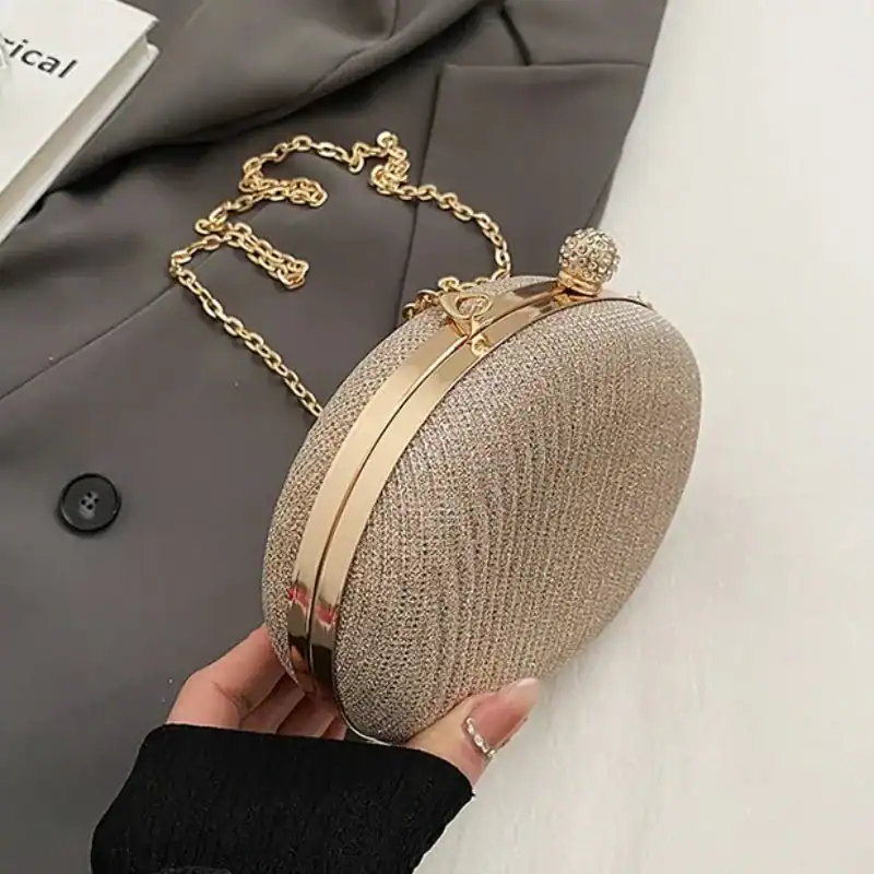 Beige oval festclutch med gyllene kedjehandtag och strassbesättning.
