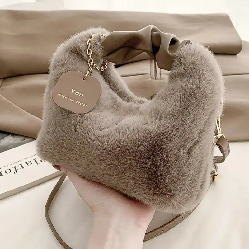 Beige pälsväska med handtag och axelrem, mjuk pälsdesign för dam.