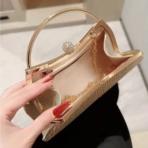 Beige plisserad clutch med guldaktig metallram och pärlhållare.
