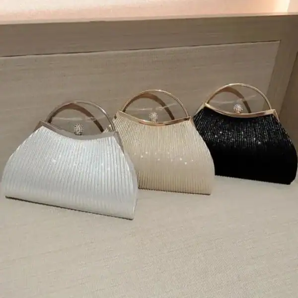 Tre plisserade clutch-hållare i silver, beige och svart med glittrande detaljer.