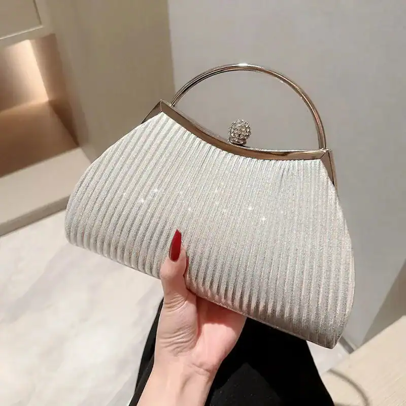 Beige plisserad clutch med metallhandtag och strass.