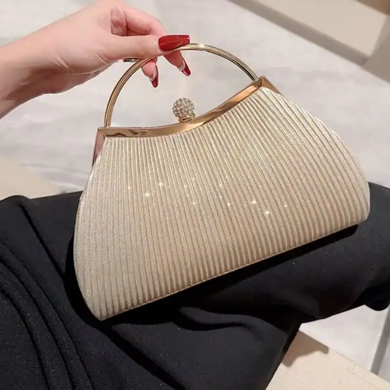 Beige plisserad clutch med guld handtag och pärla.