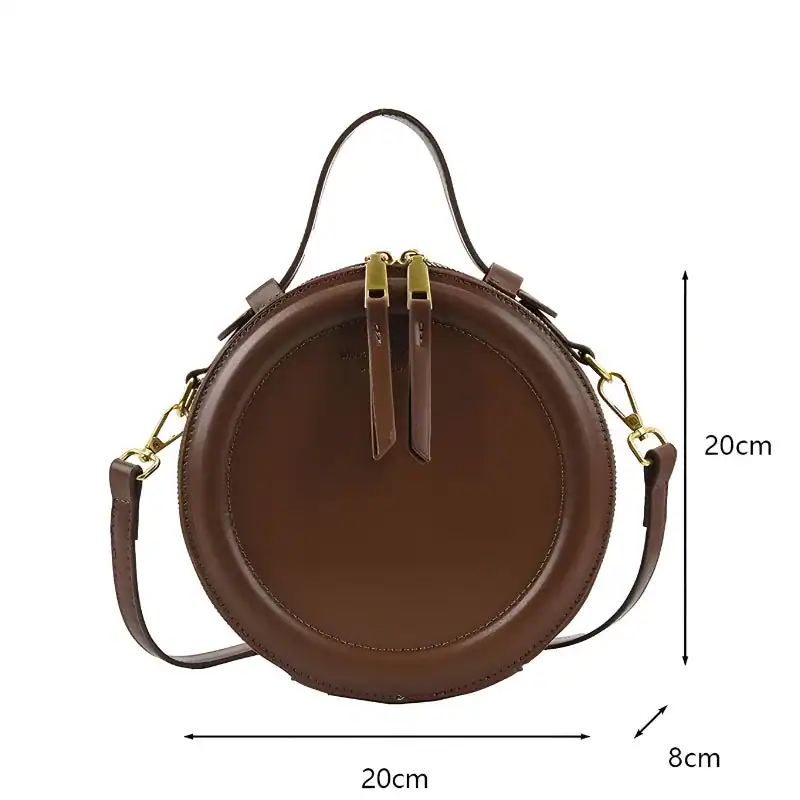 Brun rund axelväska med axelrem, 20 cm diameter, läderliknande material.