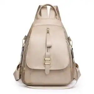 Beige ryggsäck dam med guldaktiga detaljer och praktiskt design.