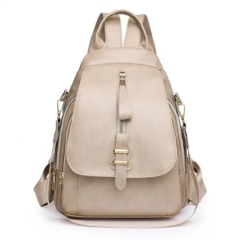 Beige ryggsäck dam med guldaktiga detaljer och praktiskt design.