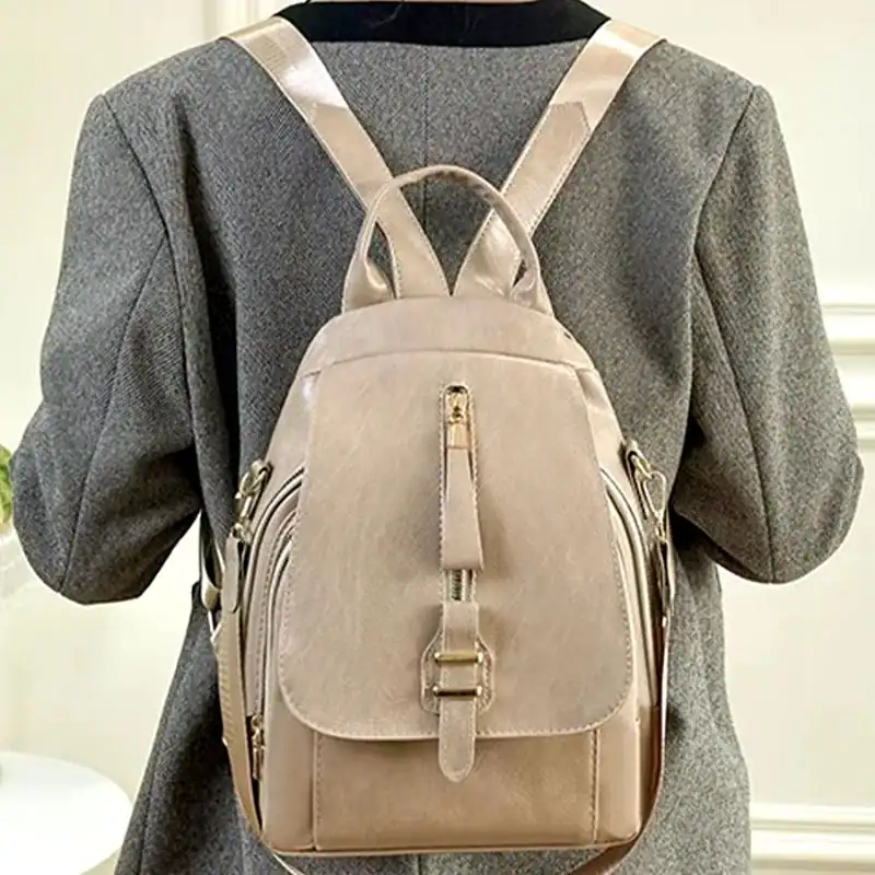 Beige ryggsäck dam med silverfärgade dragkedjor och handtag.