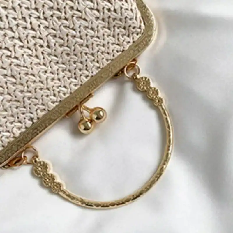 Beige stråclutch med guld handtag och detaljer.