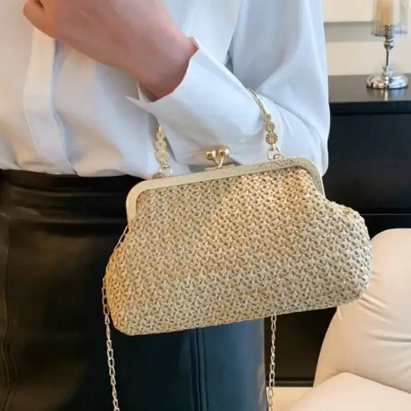 Beige stråclutch med gyllene kedja och karmelkäpp, trendig sommarhandväska.