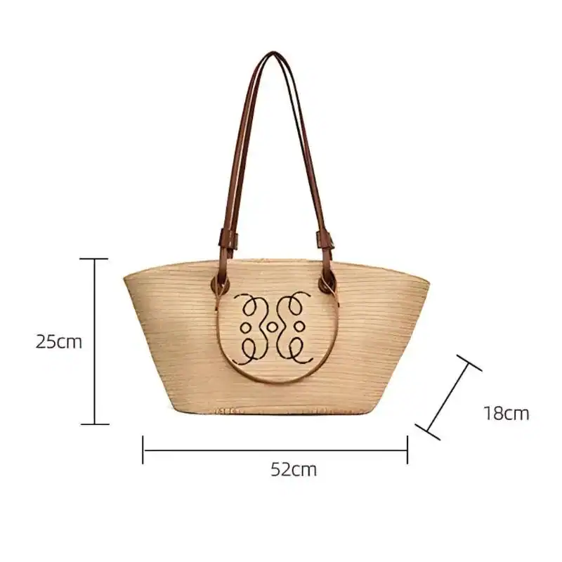 Beige stråkorg med bruna handtag och dekorativt mönster, 52x25x18 cm.