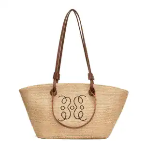 Beige stråkorg med bruna handtag och dekorativt mönster.